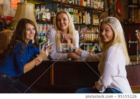 Girls in pub club gossiping and talking Girls in pub club gossiping and talking 95155126