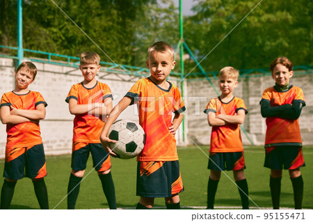 Future football champions. Little boys, kids in sports uniform posing with ball at soccer school stadium. Concept of sport, studying, achievements, success Future football champions. Little boys, kids in sports uniform posing with ball at soccer school stadium. Concept of sport, studying, achievements, success 95155471
