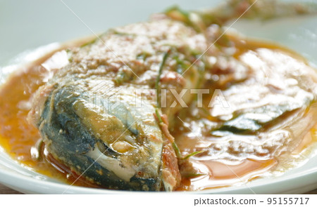 spicy boiled mackerel topping chop lemon grass in red curry sauce on plate 95155717