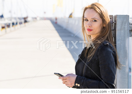 Girl using mobile phone texting on smartphone Girl using mobile phone texting on smartphone 95156517