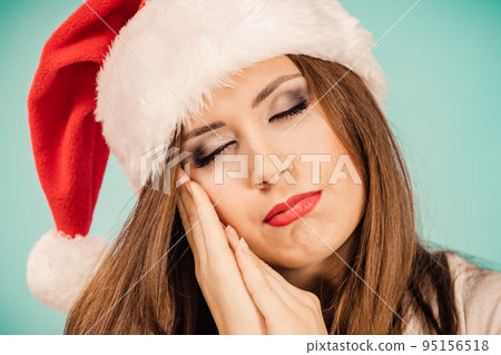Woman in santa hat being sleepy Woman in santa hat being sleepy 95156518