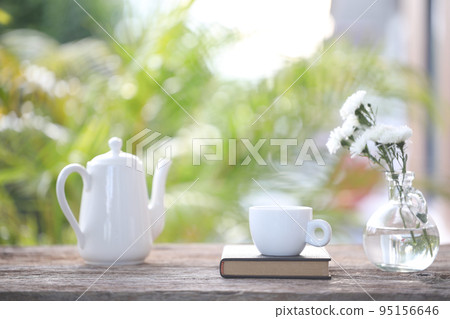 Tea cup and white tea pot with white chrysanthemum in vase Tea cup and white tea pot with white chrysanthemum in vase 95156646