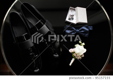 Close up of modern man accessories. Blue bowtie, black shoes Close up of modern man accessories. Blue bowtie, black shoes 95157155