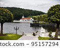 House and stone foutain in a forest on a lake 95157294