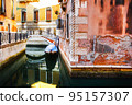 Boat moored between colorful houses. Canals in Venice, Italy 95157307