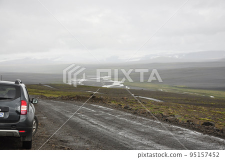 Gray SUV on a gravel road in Iceland 95157452