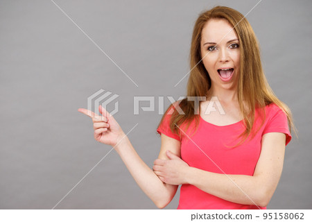 Woman pointing, surprised face expression 95158062