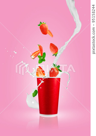 Strawberry berries falling in paper takeaway cup with milk splashes. Strawberry smoothie splash. Strawberry berries falling in paper takeaway cup with milk splashes. Strawberry smoothie splash. 95158244