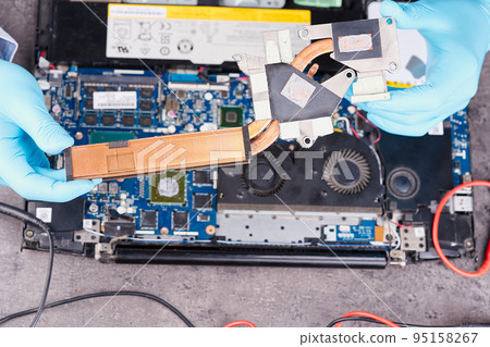 Hands fixing motherboard of pc or laptop notebook close up in service. Laptop repair service. 95158267