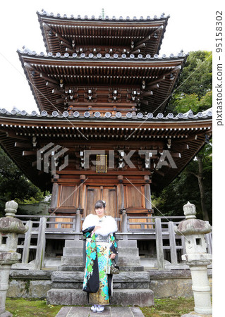 一位身穿白色背景綠松石圖案和服的成年女性，日式外景拍攝，成人儀式 95158302