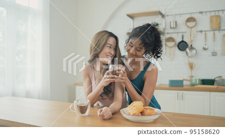 Holiday concept of 4k Resolution. Asian women having coffee together in the kitchen. Young women are in a mutual lesbian love relationship. Holiday concept of 4k Resolution. Asian women having coffee together in the kitchen. Young women are in a mutual lesbian love relationship. 95158620