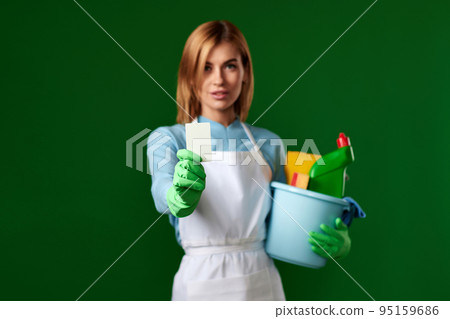 woman with bucket with cleaning supplies showing empty card 95159686