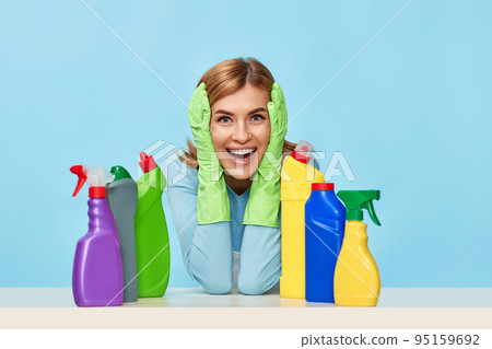 blonde young woman surrounded with cleaning agents blonde young woman surrounded with cleaning agents 95159692
