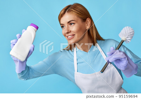 woman in rubber gloves holding toilet brush and bottle of detergent woman in rubber gloves holding toilet brush and bottle of detergent 95159694