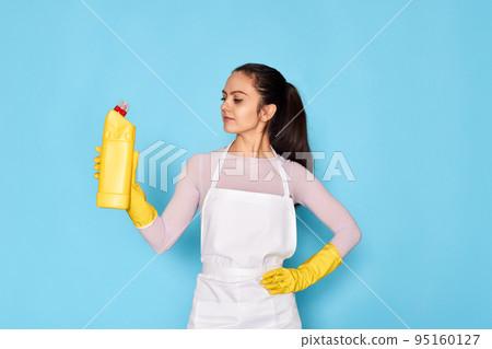 woman in gloves and cleaner apron holding bottle of detergent 95160127