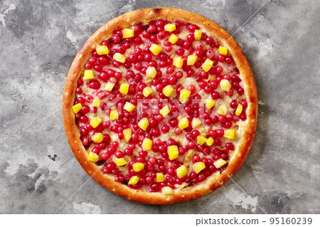 Sweet pizza with red currants, pineapple on melted mozzarella with condensed milk on gray surface Sweet pizza with red currants, pineapple on melted mozzarella with condensed milk on gray surface 95160239