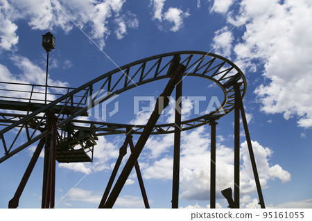 Attraction roller-coaster (switchback) on the background of the cloudy sky Attraction roller-coaster (switchback) on the background of the cloudy sky 95161055