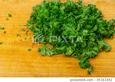 Fresh Green Chopped Parsleyon Wooden Cutting Board Background Fresh Green Chopped Parsleyon Wooden Cutting Board Background 95161842