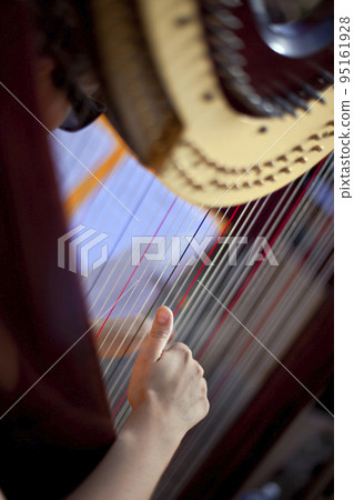 Harpist hand on his instrument 95161928
