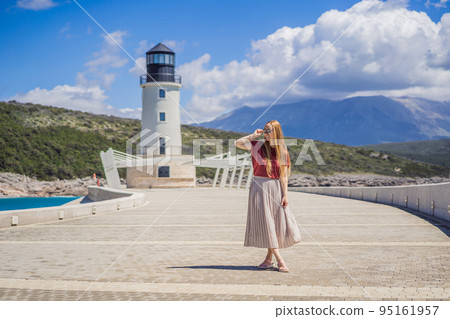 Woman tourist enjoying the views of Architecture and luxury yachts in Lustica Bay, Montenegro. Travel around Montenegro concept. Go Everywhere 95161957