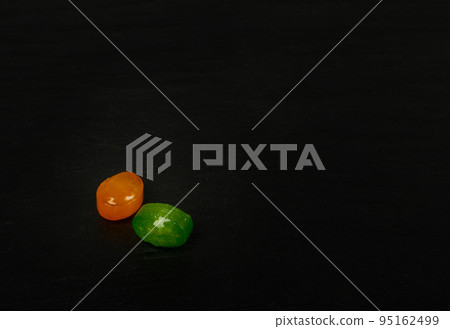 Colorful Hard Candies on Black Texture Background 95162499