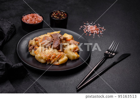 Delicious vegetable stew with beef, potatoes, carrots and cabbage in a black plate 95163513