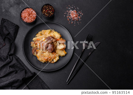 Delicious vegetable stew with beef, potatoes, carrots and cabbage in a black plate 95163514