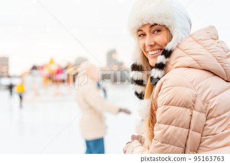 Winter woman portrait. Beautiful middle age caucasian female standing outdoor dressed funny fluffy hat looking camera smile Winter woman portrait. Beautiful middle age caucasian female standing outdoor dressed funny fluffy hat looking camera smile 95163763