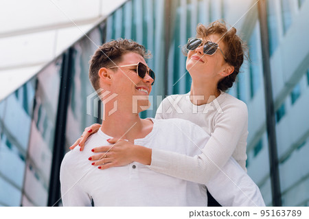 Happy young caucasian urban couple laughing and doing piggyback at outdoors Happy young caucasian urban couple laughing and doing piggyback at outdoors 95163789