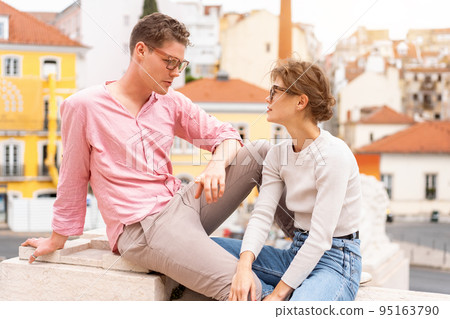 Young beautiful hipster couple in sunglasses in love sitting stairs on old city street 95163790
