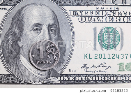 Metal coin 1 Russian ruble lies on 100 US dollars. A crisis. Economy Currency exchange. concept Metal coin 1 Russian ruble lies on 100 US dollars. A crisis. Economy Currency exchange. concept 95165223