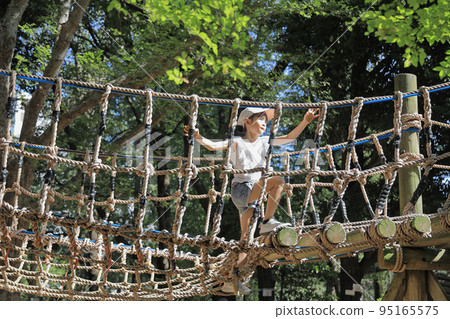 Elementary school girl playing on a tightrope (7 years old) 95165575