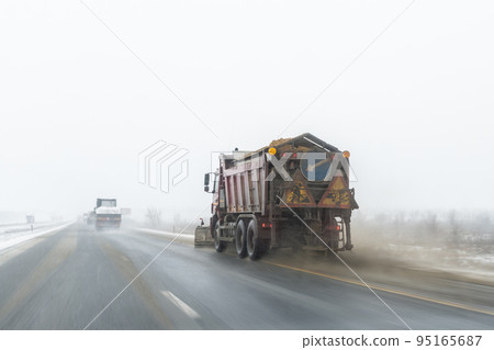 Snowplow truck removing dirty snow from city street or highway after heavy snowfalls. Traffic road situation. Weather forecast for drivers. Seasonal road maintenance. Bad conditions, slippery freeway Snowplow truck removing dirty snow from city street or highway after heavy snowfalls. Traffic road situation. Weather forecast for drivers. Seasonal road maintenance. Bad conditions, slippery freeway 95165687