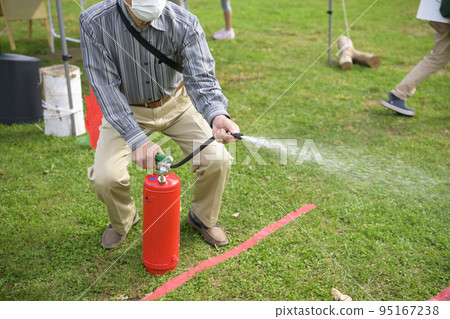 A man who participated in a fire extinguisher drill at a disaster prevention event 95167238