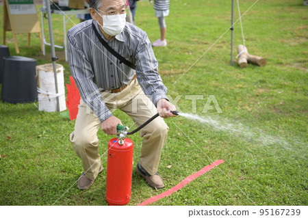 A man who participated in a fire extinguisher drill at a disaster prevention event 95167239