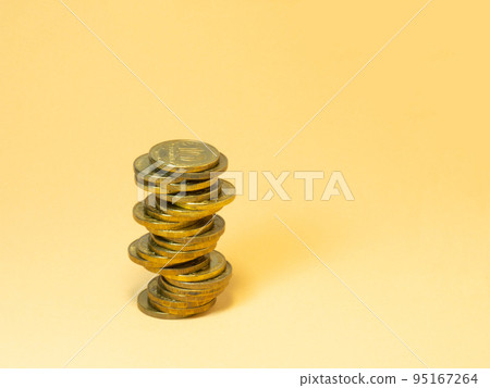 A turret made of coins. Money on yellow background A turret made of coins. Money on yellow background 95167264