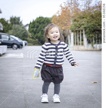Little girl having fun in autumn park Little girl having fun in autumn park 95168156