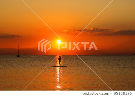 Dusk on the Zushi coast, the silhouette of a young man enjoying SUP in the sunset 95168186