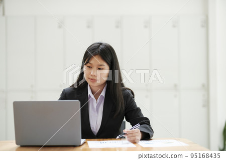 Businesswoman working at office using laptop. 95168435