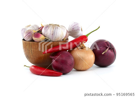 Garlic in bowl near to chili pepper and onions 95169565