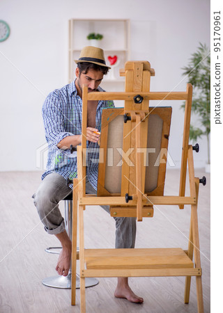 Young man enjoying painting at the studio 95170961