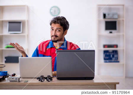 Young male repairman repairing computer Young male repairman repairing computer 95170964