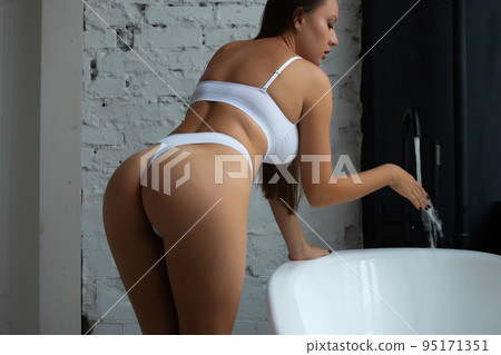 Unrecognizable naked female in bathroom 95171351