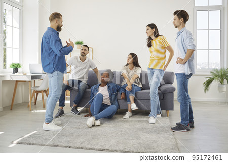 Group of diverse friends meeting in living room, talking and listening to each other Group of diverse friends meeting in living room, talking and listening to each other 95172461