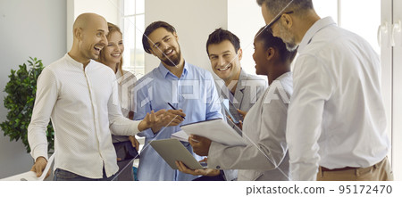 Group of colleagues are talking and joking together while creating and discussing business plan. 95172470