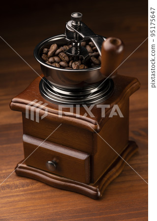 Grind coffee beans with a coffee grinder Grind coffee beans with a coffee grinder 95175647