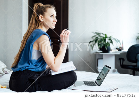Job interview, Finding New Job. Young woman writing in Planner diary notes about job interview sitting near laptop on the bed at home 95177512