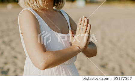 Praying meditating woman, reading mantras, directs thoughts, requests or gratitude to universe 95177597