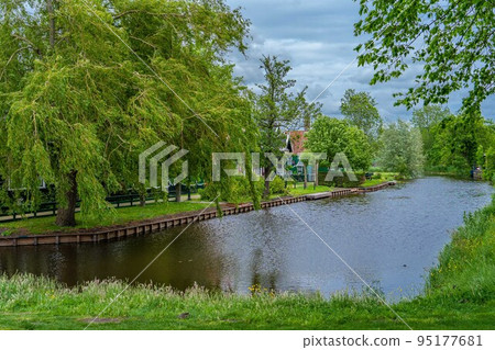 Rural landscape with windmill in Zaanse Schans. Holland, Netherlands. Authentic Zaandam mill. Beautiful Netherland landscape. 95177681