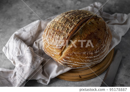 Homemade sourdogh whole round bread on grey background. Home baking concept. 95178887